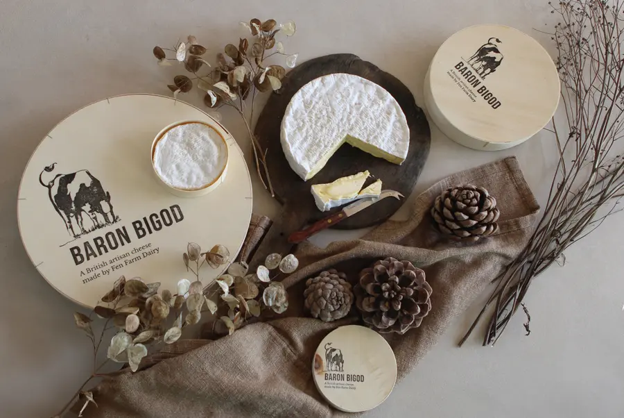 Baron Bigod cheese in its Fen Farm Dairy packaging, styled with dried flowers